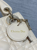 Christian Dior charm tag on white leather strap with gold-tone chain hardware