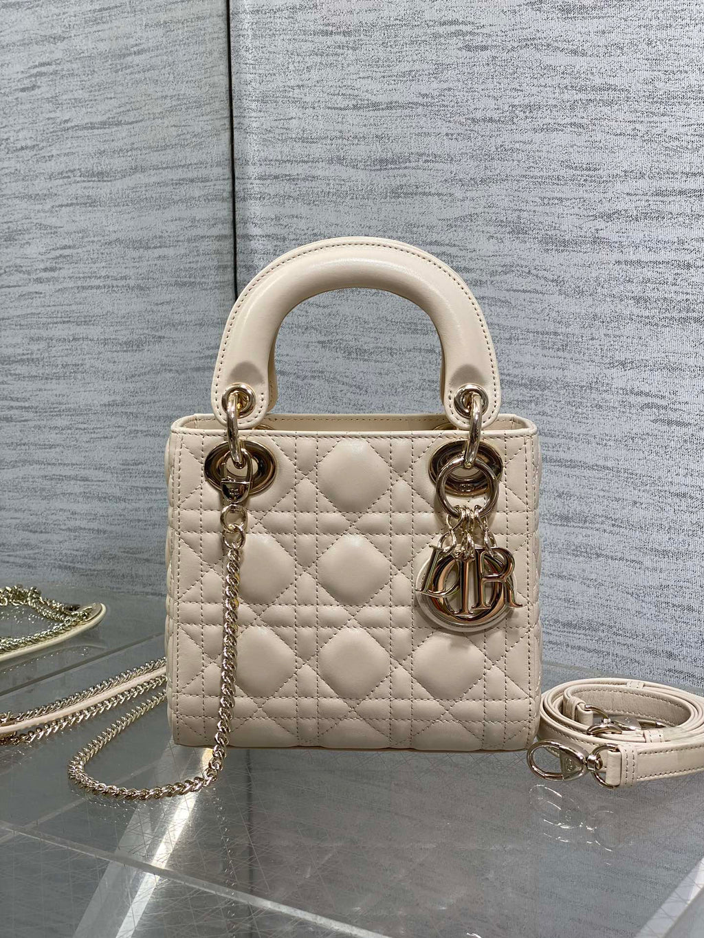 Light beige quilted Dior handbag with top handles, gold-tone hardware and chain strap