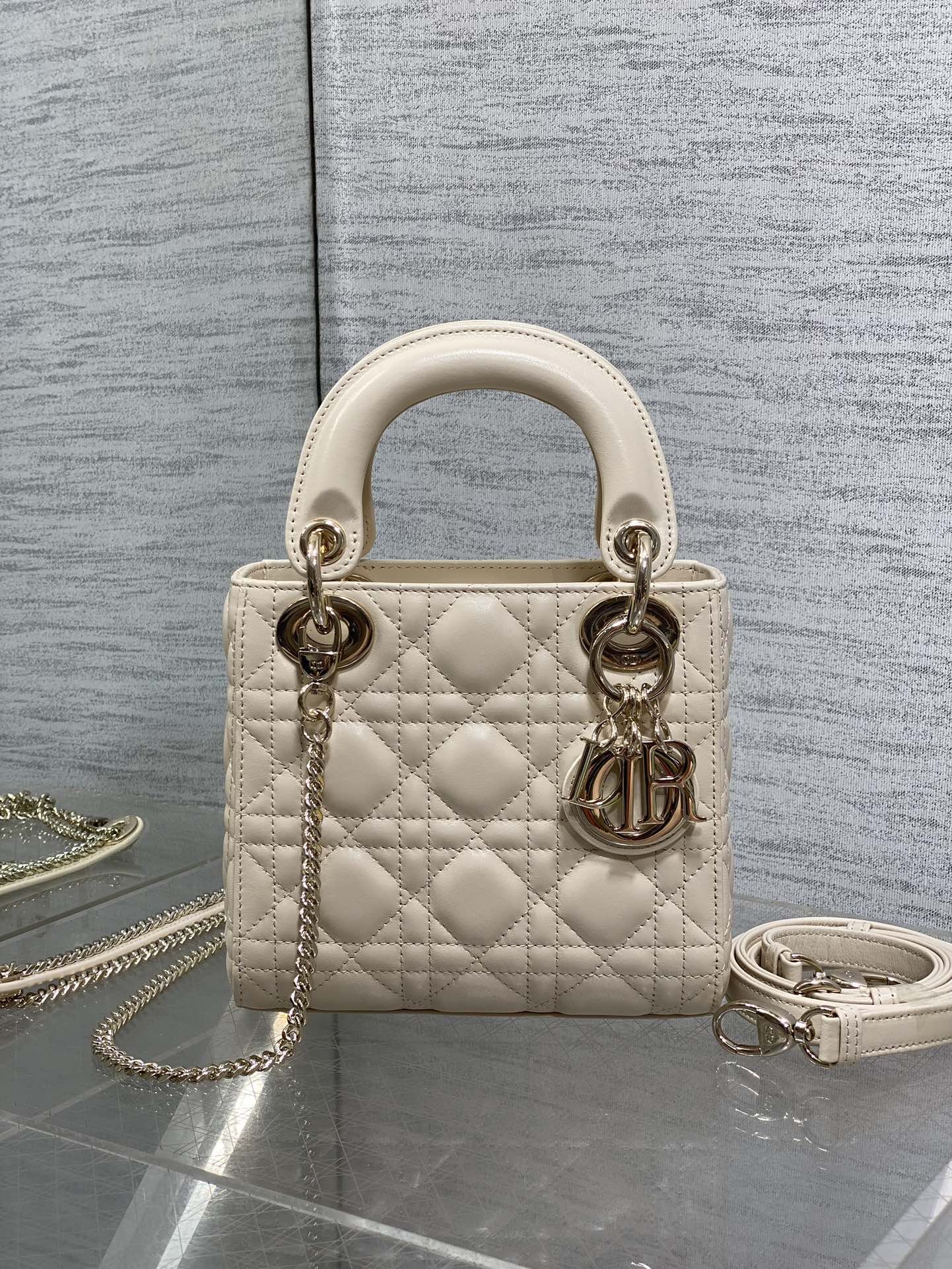 Light beige quilted Dior handbag with top handles, gold-tone hardware and chain strap