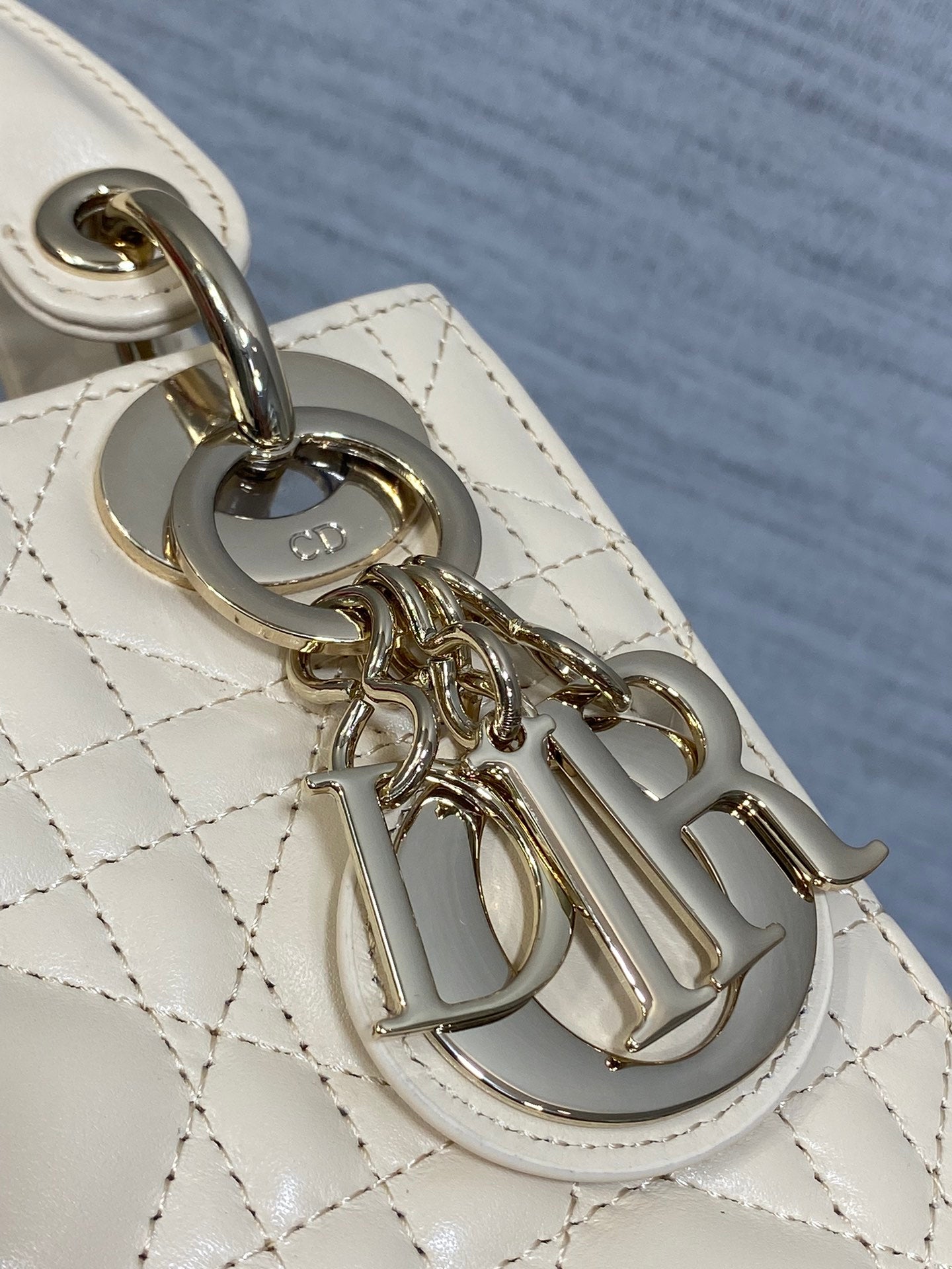 Dior handbag metal charm and clasp on quilted light beige leather