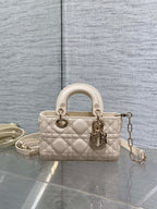 Cream quilted Dior bag with top handles and dangling chain strap