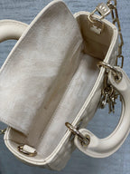 Cream Dior bag interior view with strap attachments and silver-tone hardware