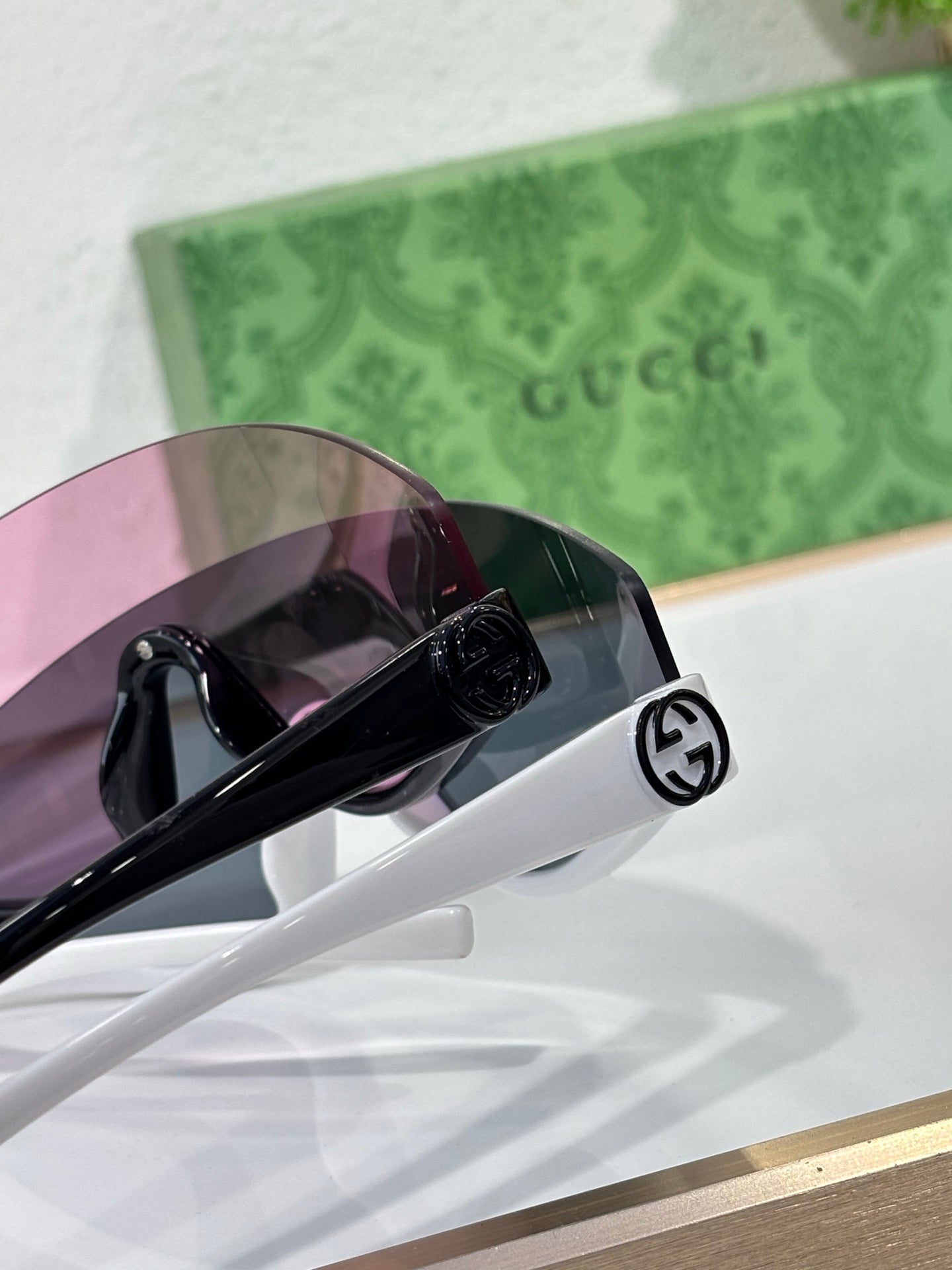 Gucci sunglasses temple close-up with black circular logo detail