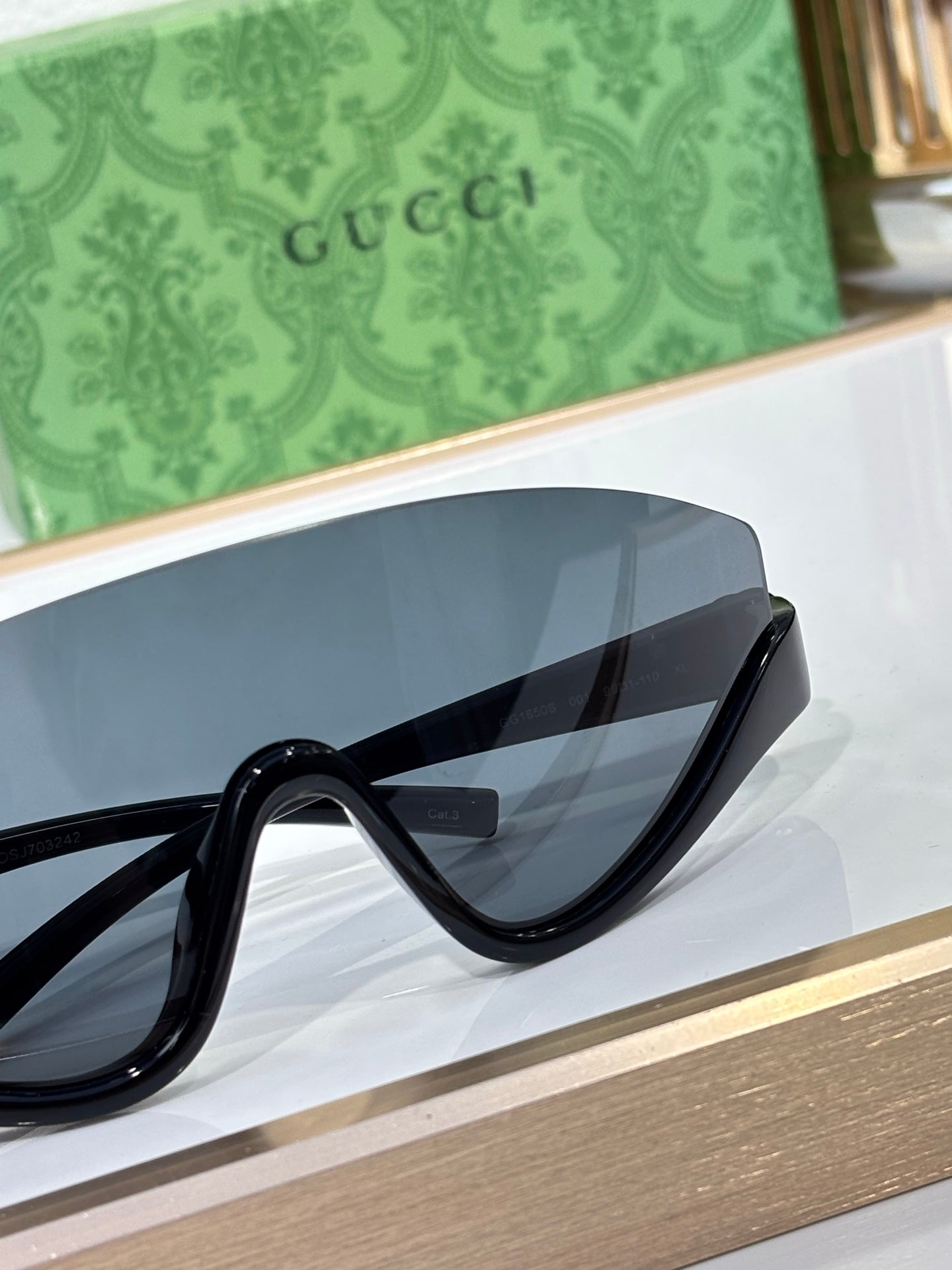 Gucci sunglasses close-up with glossy black frame and dark lens