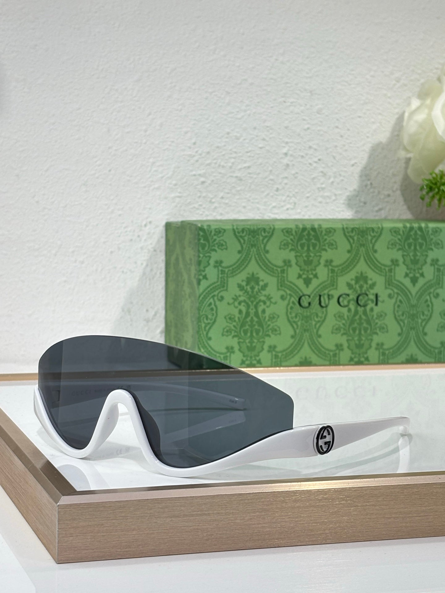 Gucci sunglasses with translucent dark lenses and white temples with logo