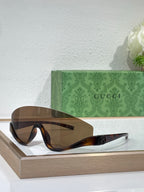 Gucci sunglasses with dark brown frames and gradient lenses