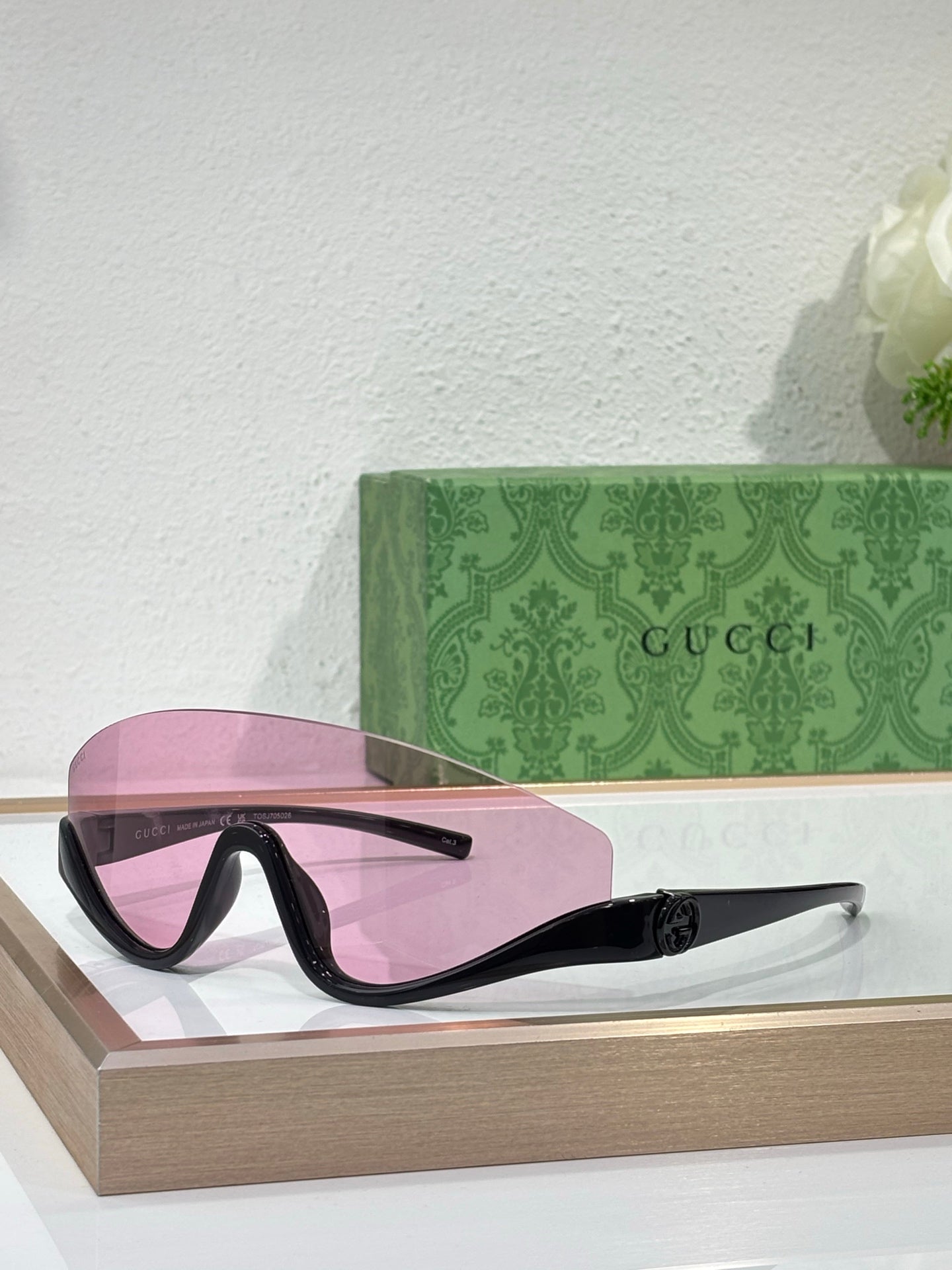 Gucci sunglasses with black frames and pink-tinted lenses