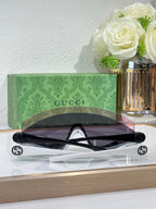 Gucci sunglasses with black frames, large lenses, and visible logo on temples