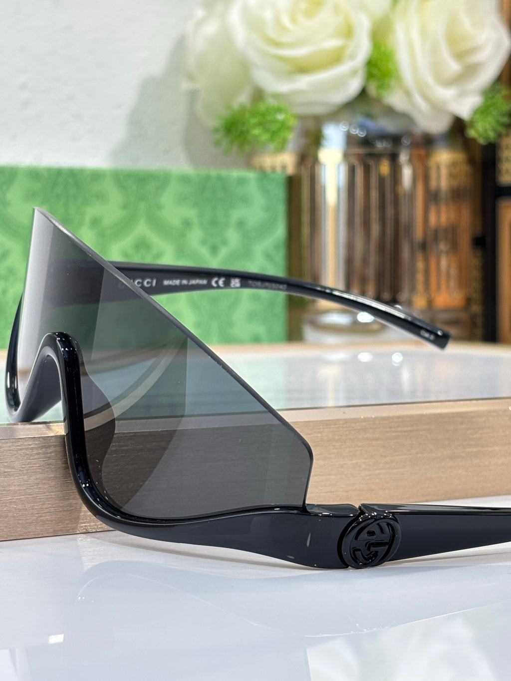 Gucci sunglasses side profile with dark lenses and black arm with logo