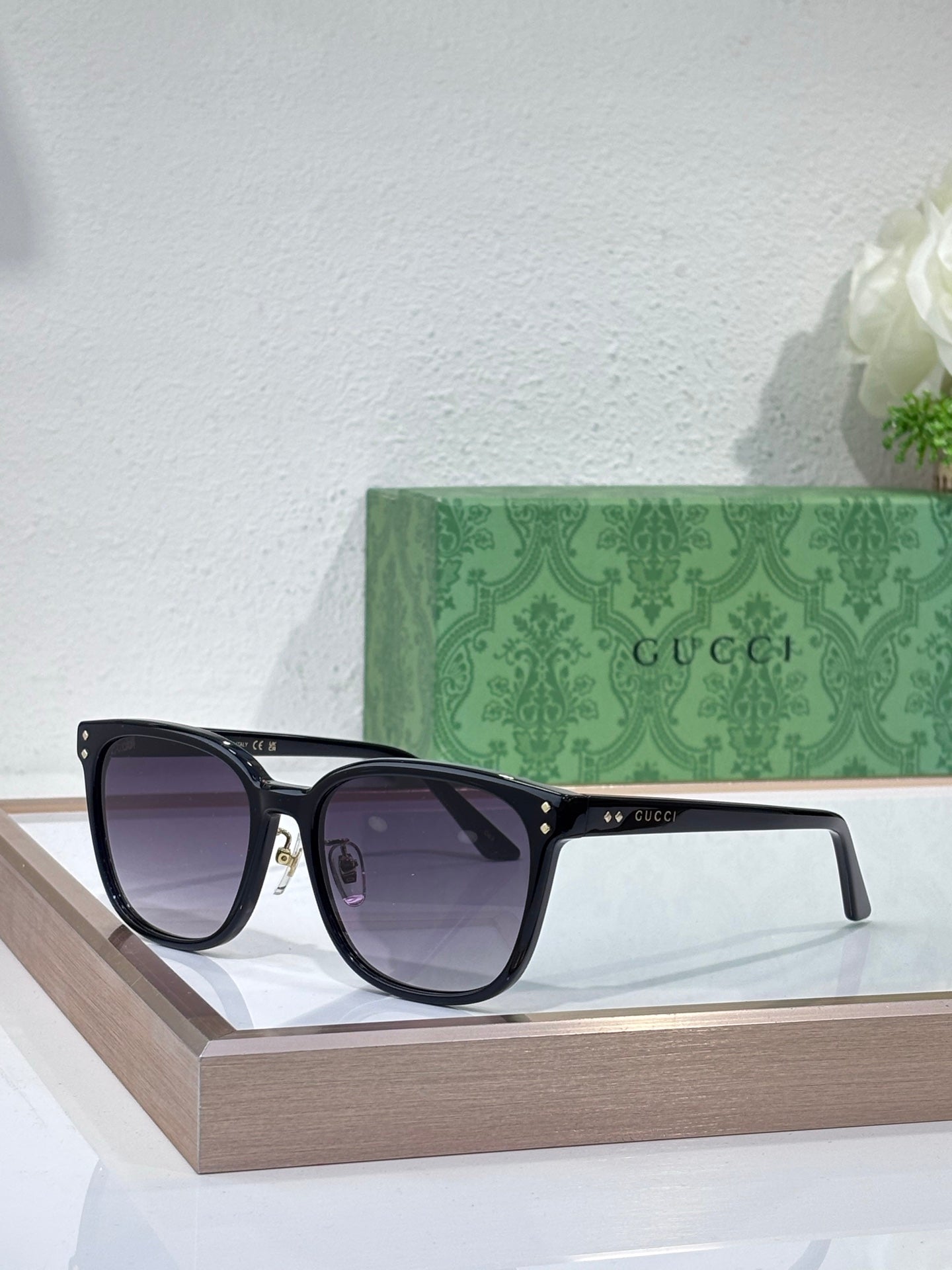 Gucci sunglasses with black frames and dark purple tinted lenses