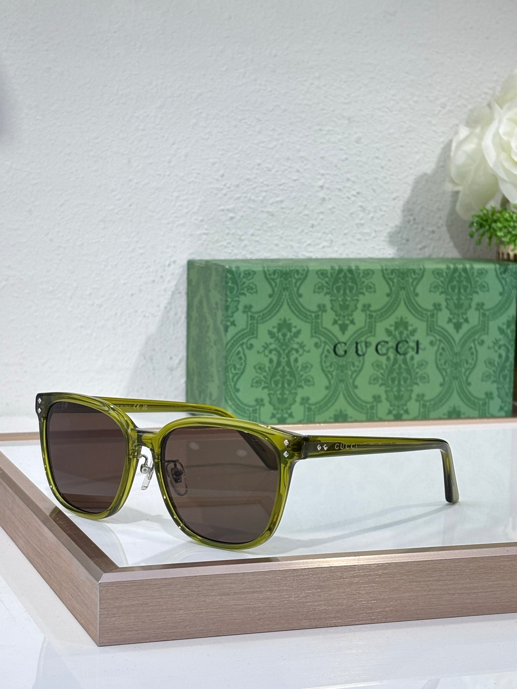 Gucci sunglasses with olive green frames and dark brown tinted lenses