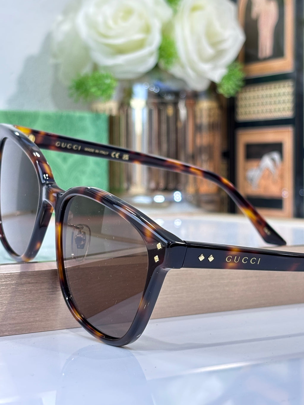 Gucci sunglasses with tortoise front, navy temples, and brown tinted lenses