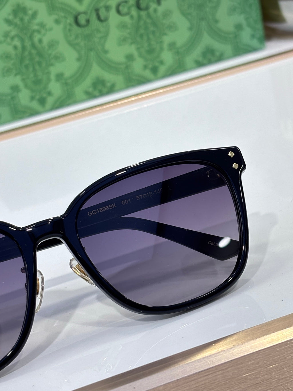 Gucci sunglasses close-up with dark navy frames and purple tinted lenses