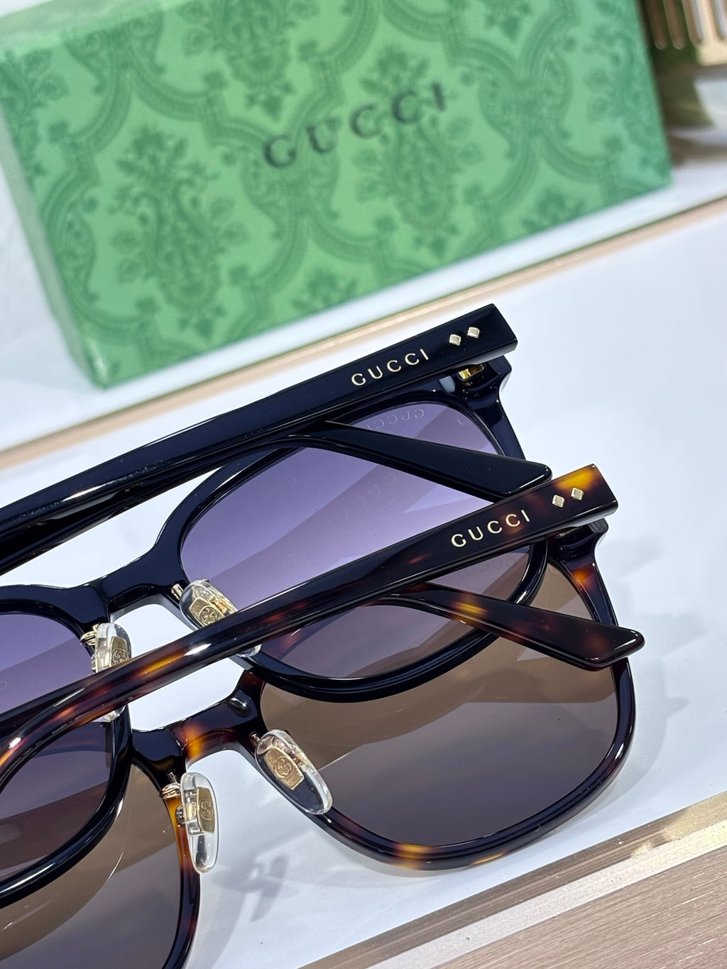 Gucci sunglasses with navy frames, tortoise accents, and dark purple tinted lenses