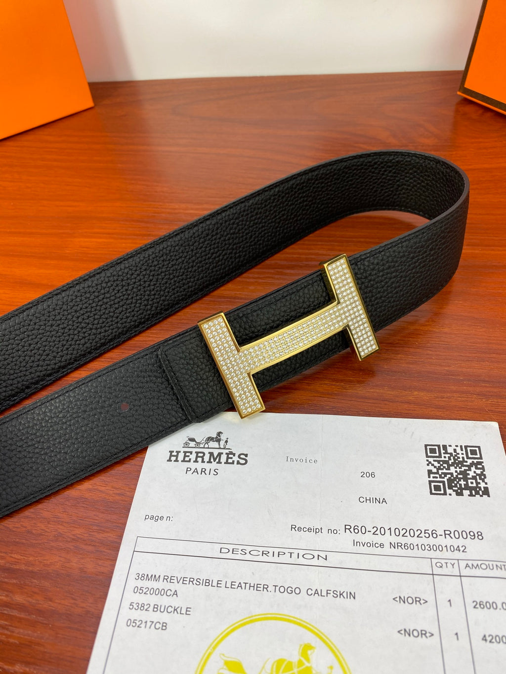 Hermes belt laid flat: black strap with gold-tone H buckle