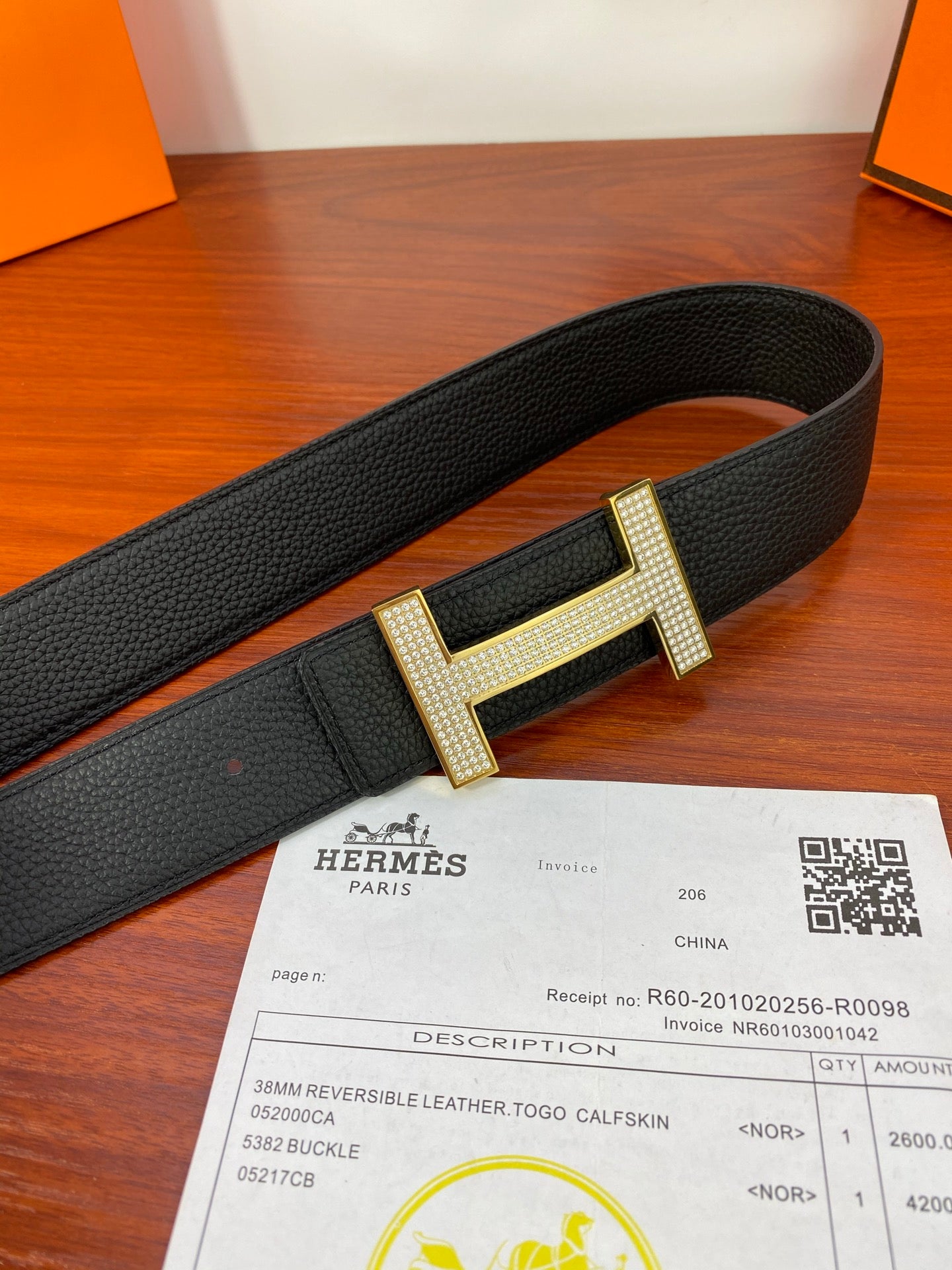 Hermes belt laid flat: black strap with gold-tone H buckle