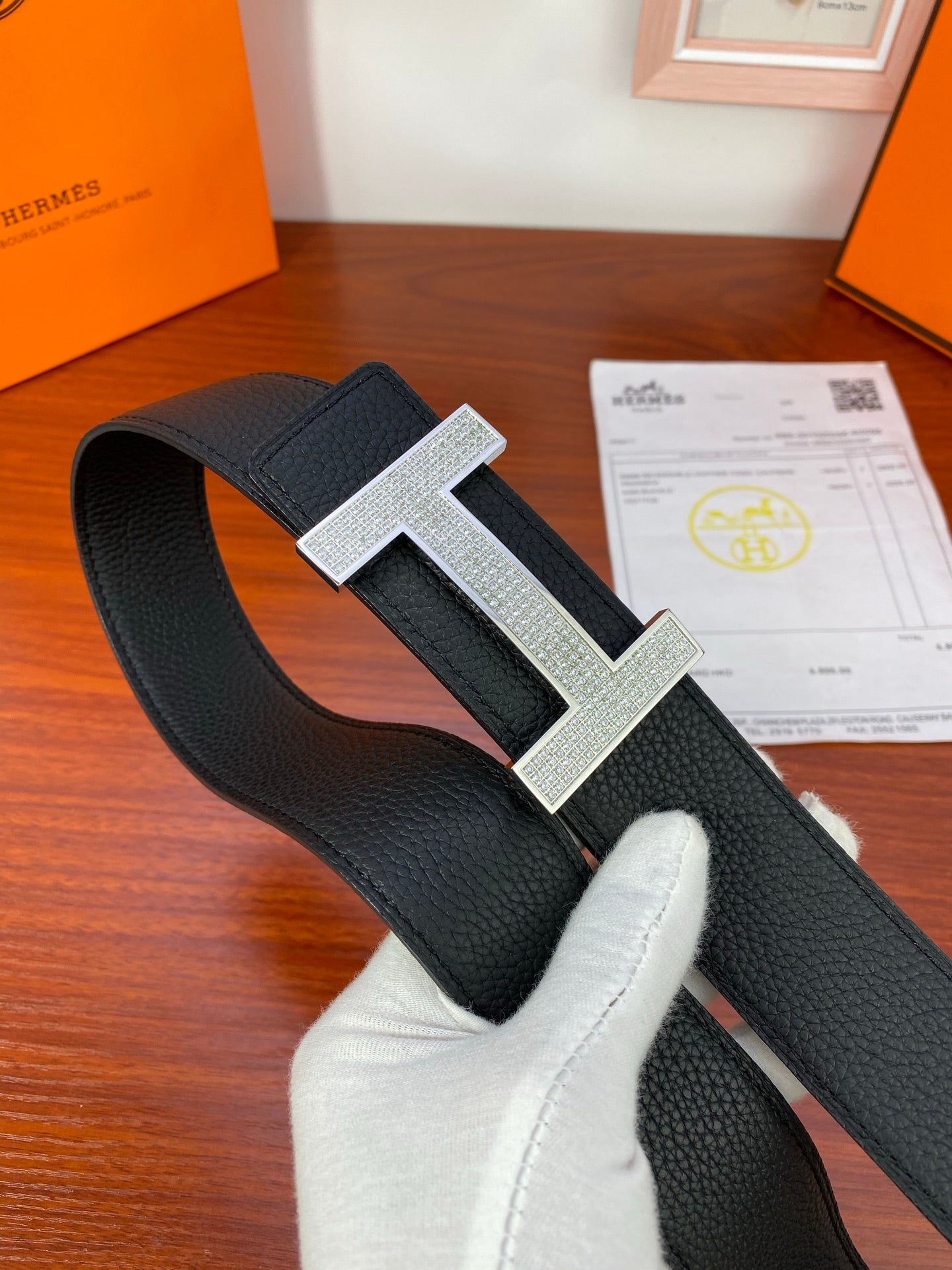 Hermes belt on display with black strap and silver-tone H buckle