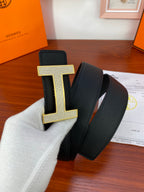 Hermes belt with black strap and gold-tone H buckle with studded edges