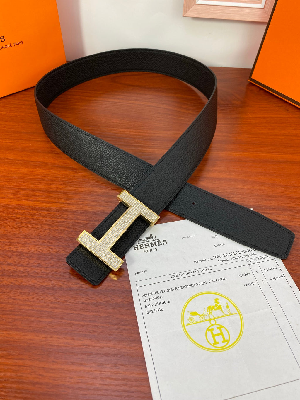 Hermes belt with black textured strap and gold-tone H buckle