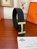 Hermes belt with black strap and gold-tone H buckle on side view