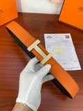 Orange leather belt with black underside and silver-toned studded H buckle