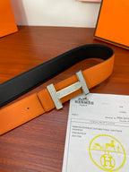 Reversible leather belt with orange and black straps, silver studded H buckle