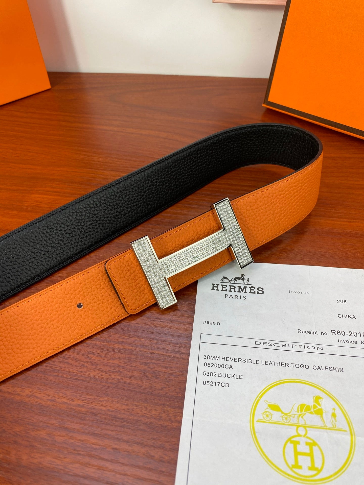 Reversible leather belt with orange and black straps, silver studded H buckle