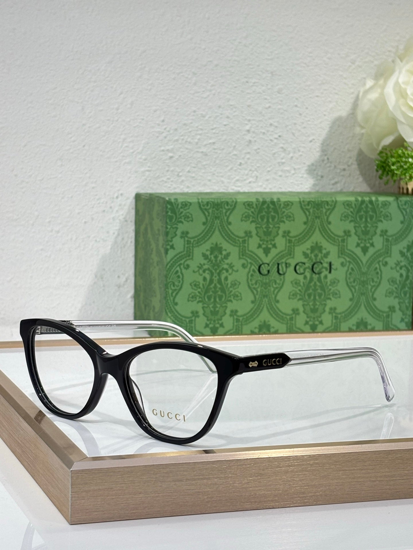 Gucci eyeglasses with black rectangular frames and clear lenses on display