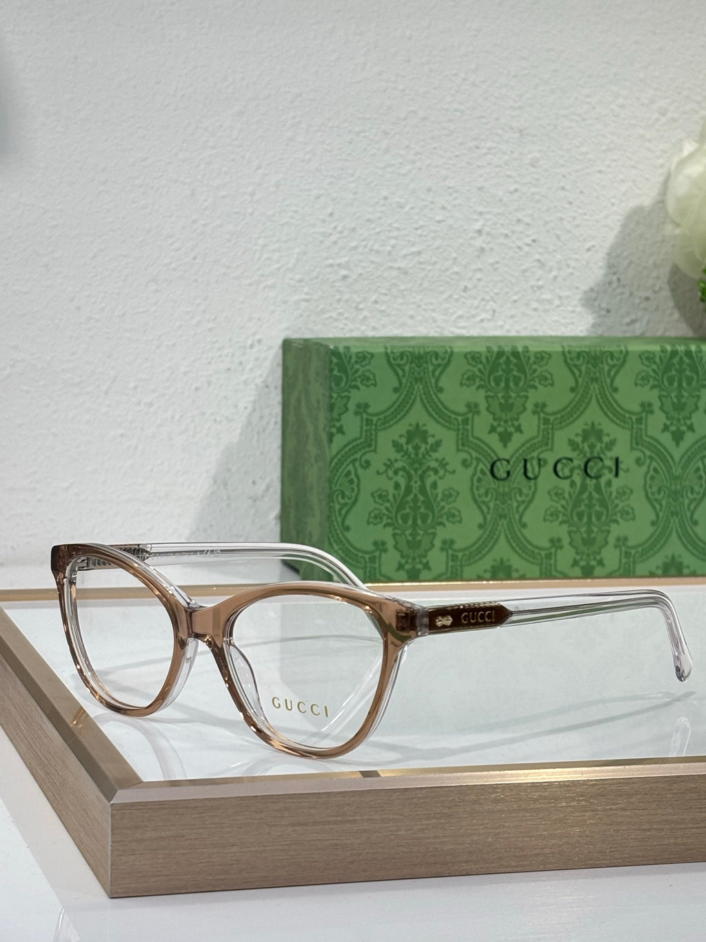 Gucci eyeglasses with clear frames, gold-toned rims, and clear lenses