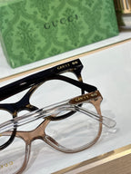 Gucci eyeglasses close-up showing black and gold-toned frames with clear lenses