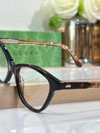 Gucci eyeglasses with black frames, gold bridge detail, and clear lenses