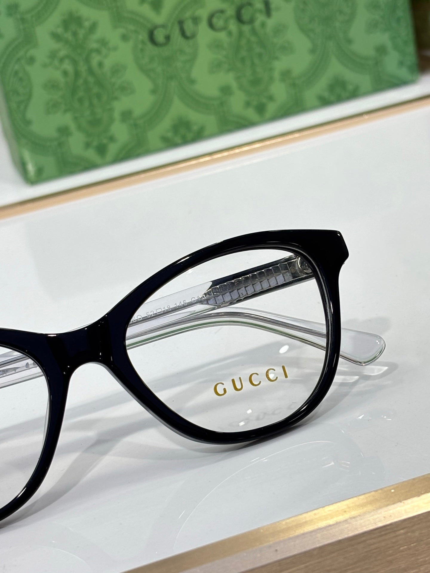 Gucci eyeglasses close-up of black round rectangular frame and clear lens