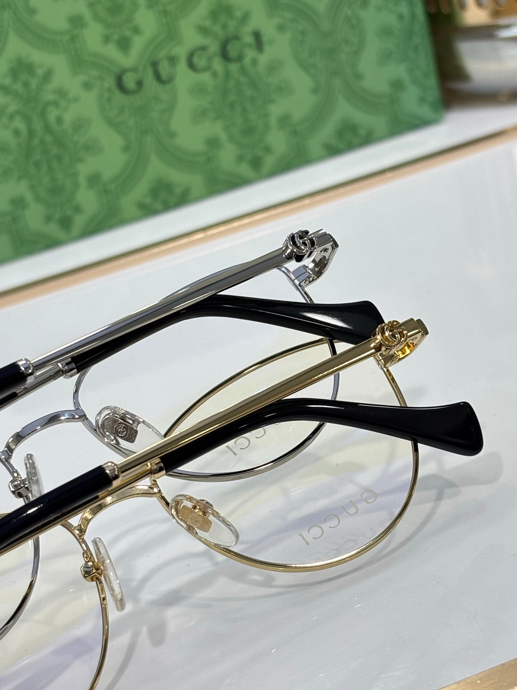Gucci eyeglasses top view with gold-tone rims and black temple arms