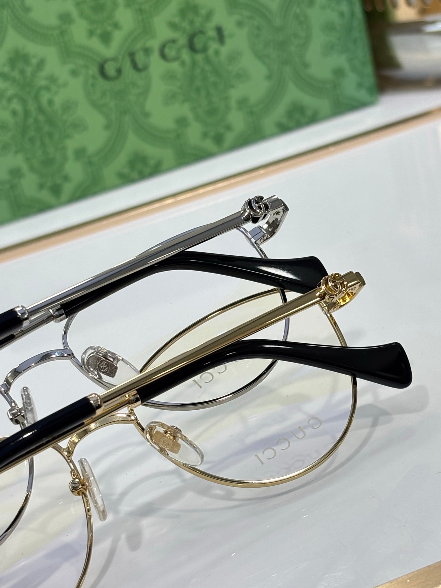 Gucci eyeglasses top view with gold-tone rims and black temple arms
