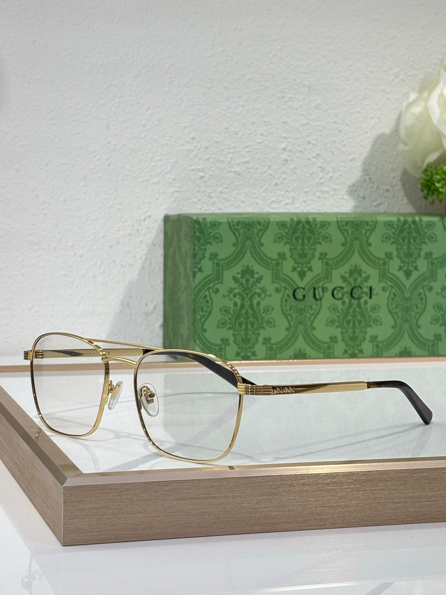 Gucci eyeglass frames with clear lenses, gold temple accents and dark top bar