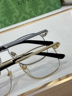 Gucci eyeglass frames shown from side with gold-toned hinges and clear lenses