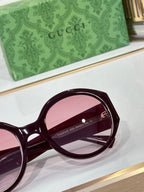 Burgundy round sunglasses close-up with Gucci logo on temple
