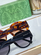 Tortoise shell sunglasses close-up with Gucci logo on temple