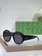 Black round sunglasses with pointed temple details and Gucci logo
