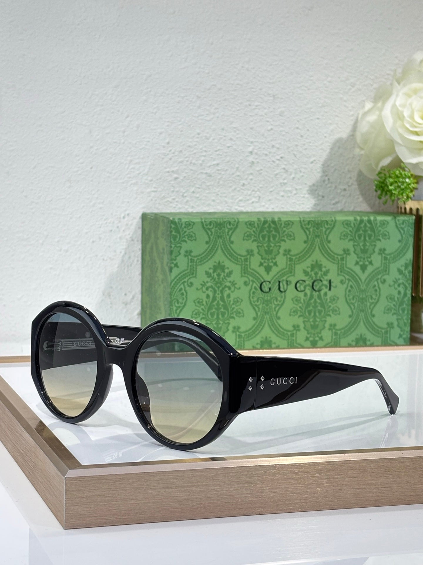 Black round sunglasses on display, Gucci logo on temple