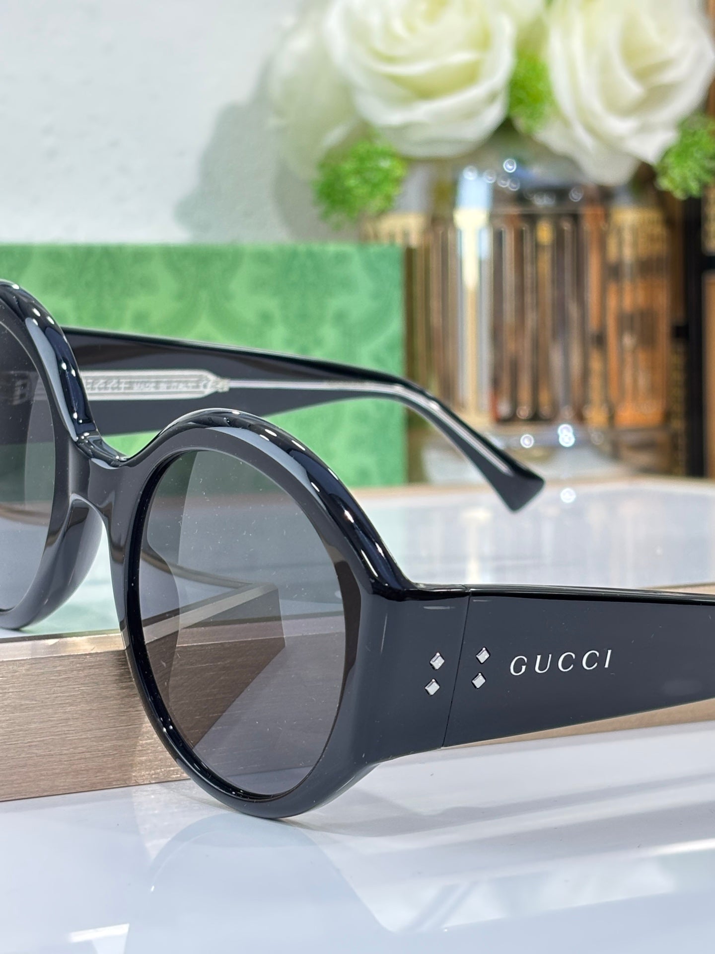 Black round sunglasses close-up with Gucci logo on arm