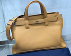 Tan leather tote bag with two top handles and front buckle strap