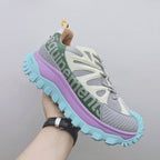 Moncler luxury sneaker, side close-up with green logo band, purple midsole, teal tread