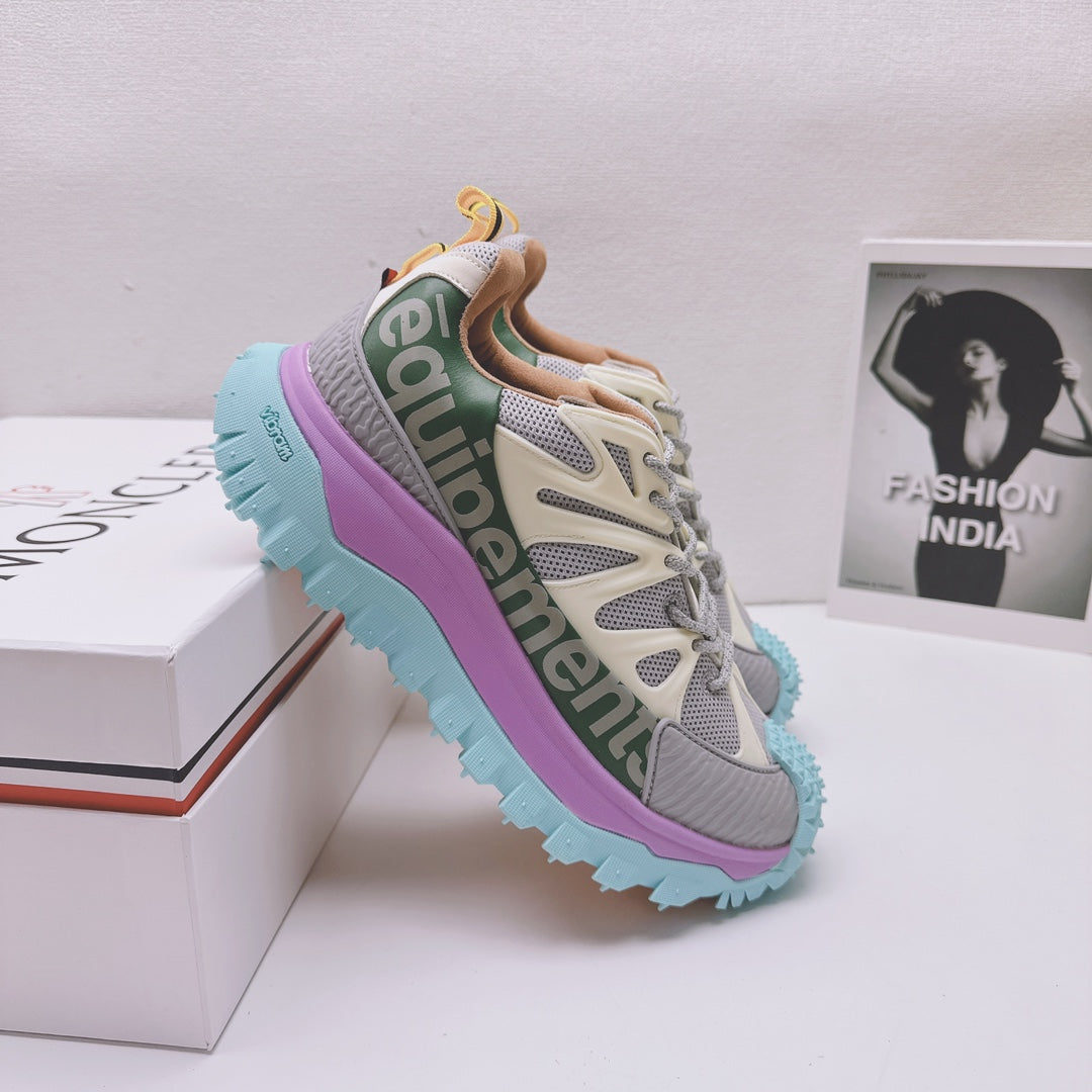 Moncler luxury sneaker, angled heel view with green logo band and purple teal platform