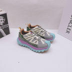 Moncler luxury sneakers pair, side view with green logo band and purple teal sole