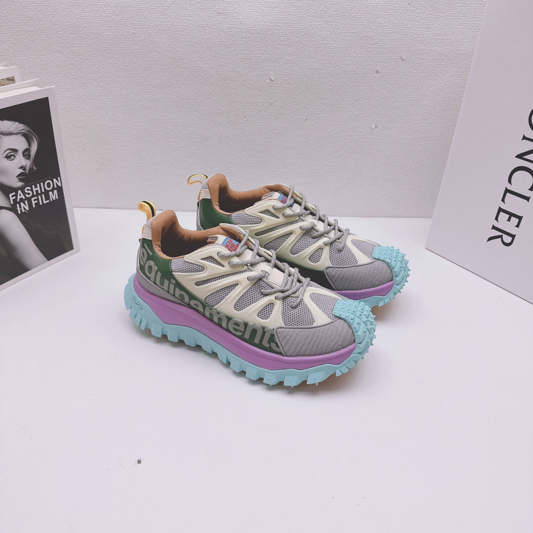 Moncler luxury sneakers pair, side view with green logo band and purple teal sole