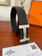 Black belt on edge with silver-toned H buckle detail, plus receipt paper