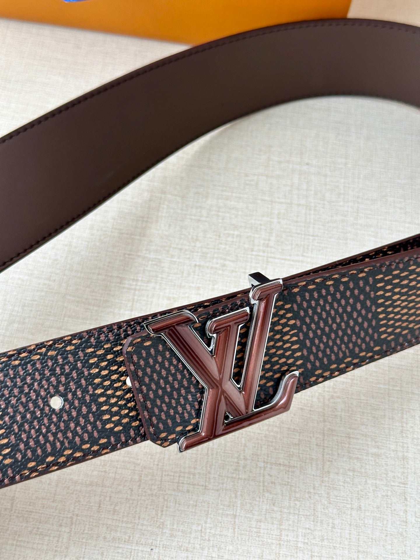 LV belt buckle in dark metal on brown leather strap