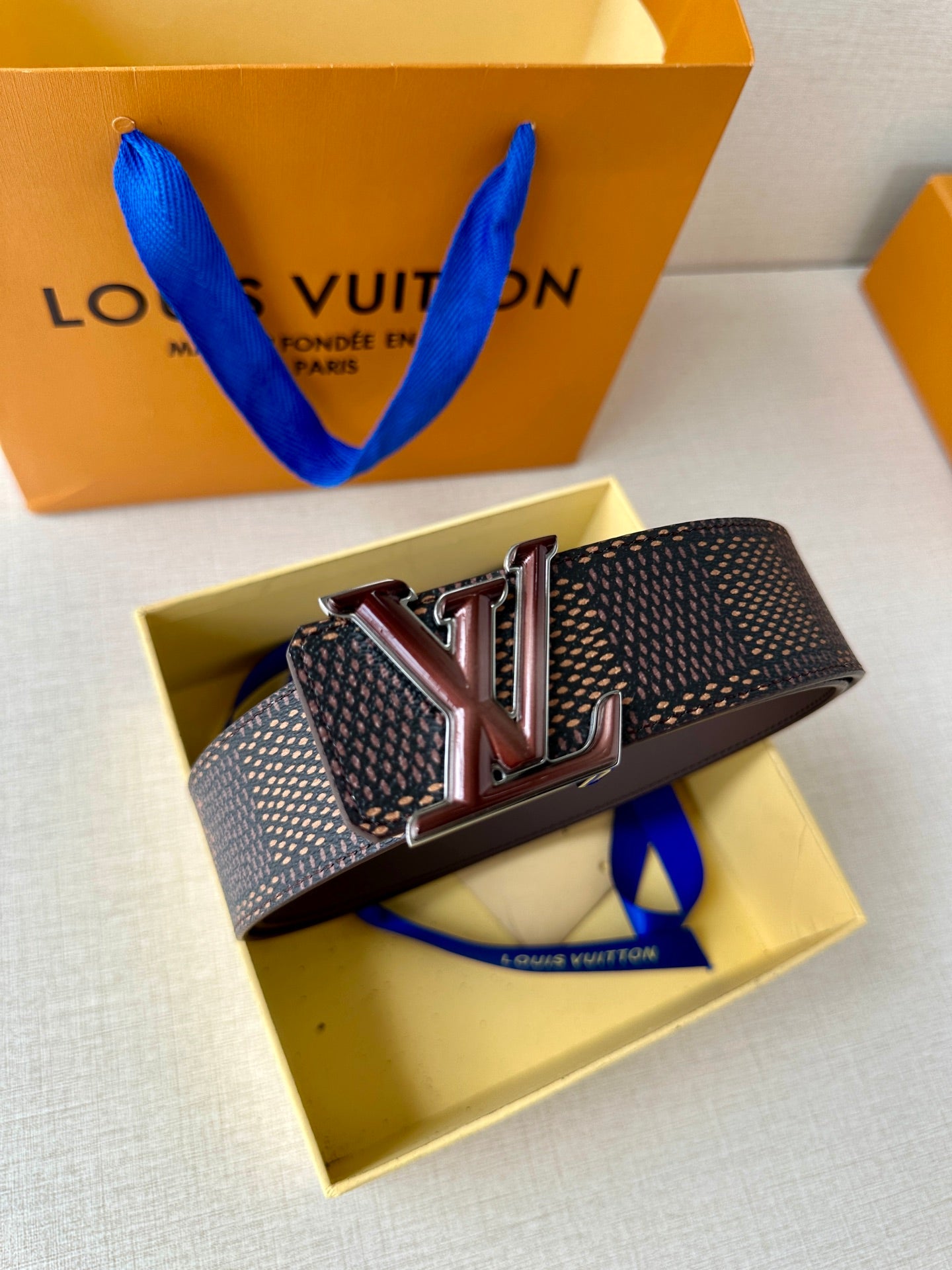 LV belt with dark monogram strap and V-style metal buckle