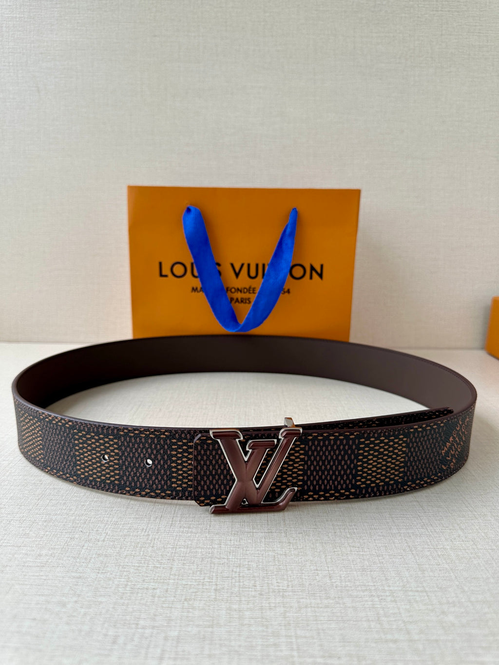 Louis Vuitton belt with dark monogram canvas strap and brown leather buckle